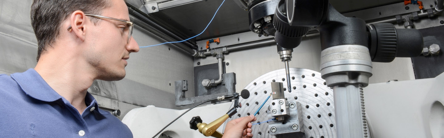 Ein Wissenschaftler macht eine Schwingungsmessung an einer Verdichterschaufel in einer Fräsmaschine.